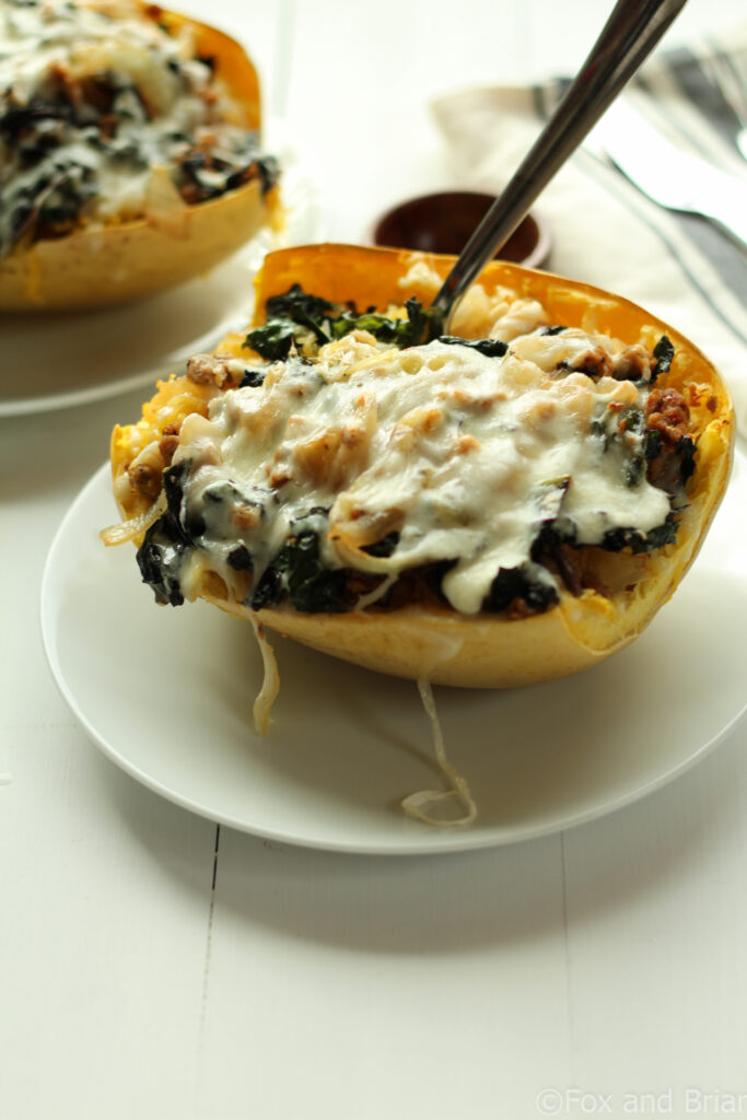 Sausage and Kale Spaghetti Squash Boats! So good! And healthy! Spicy Sausage and Garlicky Kale all topped with melty cheese make this low carb and gluten free meal perfectly satisfying.