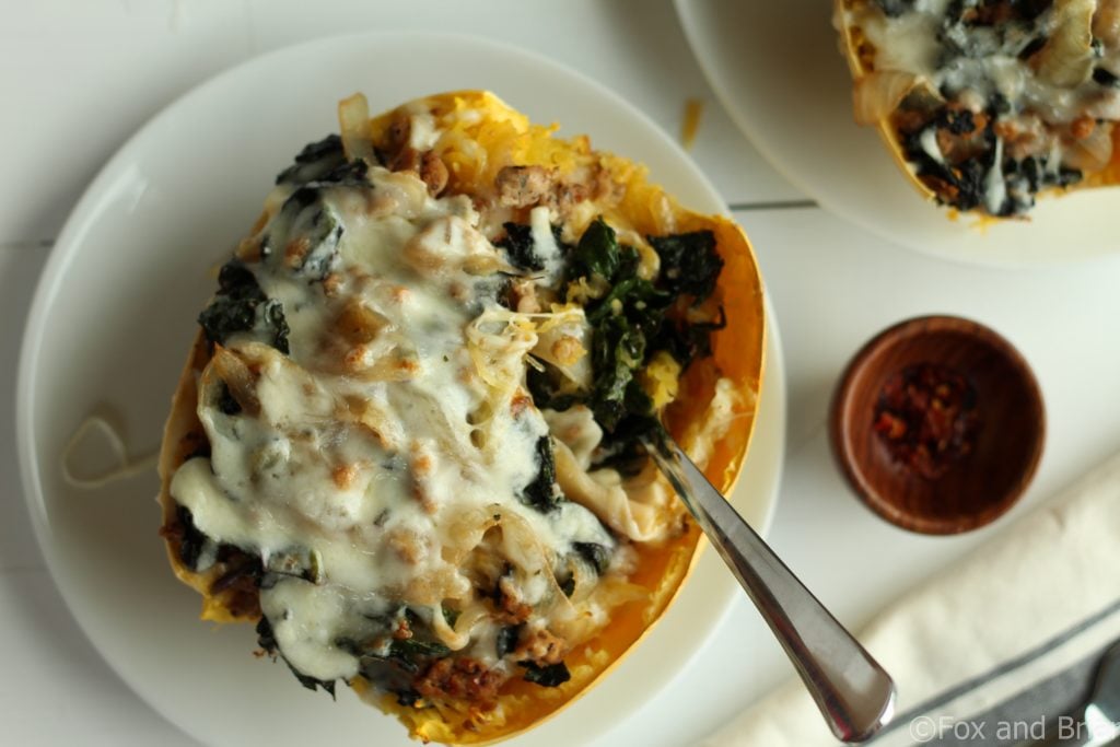 Sausage and Kale Spaghetti Squash Boats! So good! And healthy! Spicy Sausage and Garlicky Kale all topped with melty cheese make this low carb and gluten free meal perfectly satisfying.