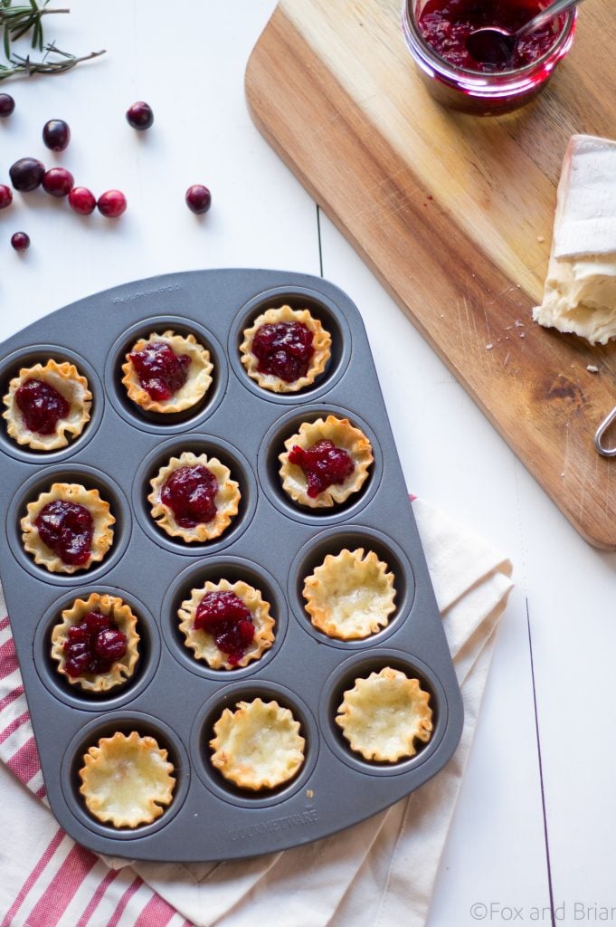 Cranberry Brie Mini Tarts. These easy, 3 ingredients appetizers are perfect for any holiday party that you will be hosting or attending. Buttery brie and sweet tart cranberry sauce in a crispy shell make adorable bite sized appetizers.