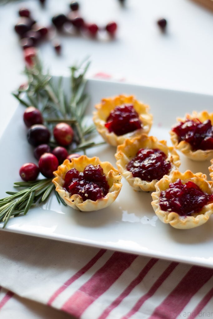 Cranberry Brie Mini Tarts. These easy, 3 ingredients appetizers are perfect for any holiday party that you will be hosting or attending. Buttery brie and sweet tart cranberry sauce in a crispy shell make adorable bite sized appetizers.