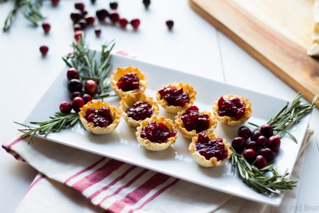 Cranberry Brie Mini Tarts. These easy, 3 ingredients appetizers are perfect for any holiday party that you will be hosting or attending. Buttery brie and sweet tart cranberry sauce in a crispy shell make adorable bite sized appetizers.