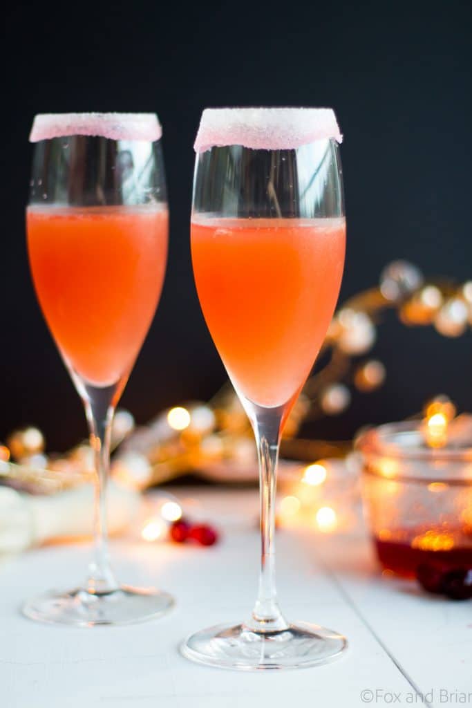 Homemade cranberry orange syrup takes this standby cocktail up a notch. Cranberry Juice, Grand Marnier, Orange juice and cranberry orange syrup combine to make a festive winter cocktail. There is a non-alcoholic mocktail version as well!