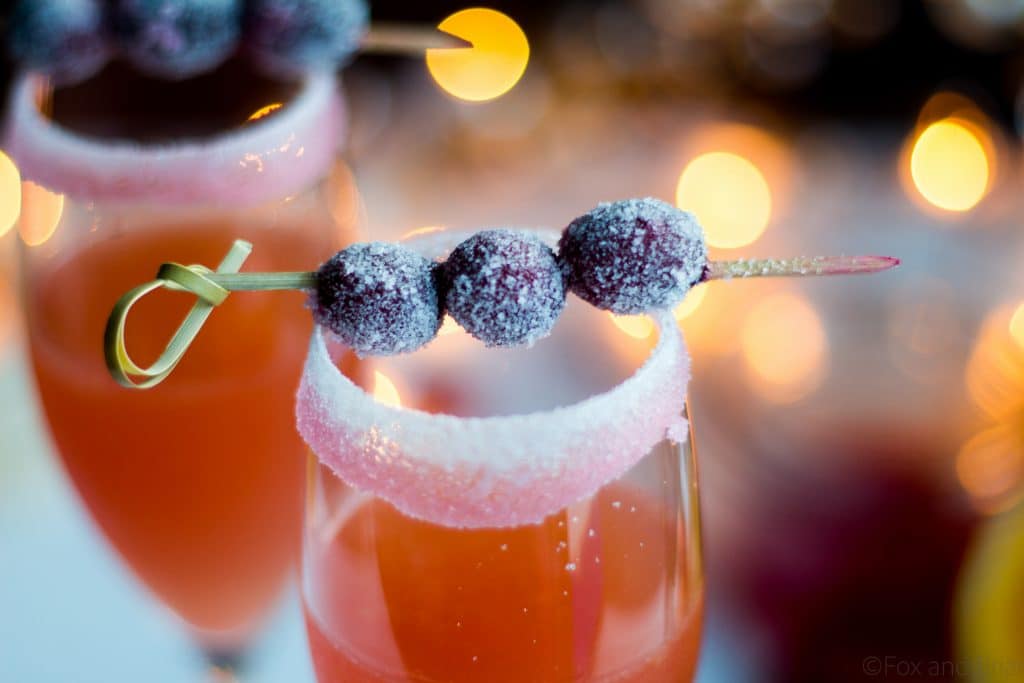 Homemade cranberry orange syrup takes this standby cocktail up a notch. Cranberry juice, Grand Marnier, Orange juice and cranberry orange syrup combine to make a festive winter cocktail. There is a non-alcoholic mocktail version as well!