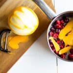 Homemade cranberry orange syrup takes this standby cocktail up a notch. Cranberry Sauce, Grand Marnier, Orange juice and cranberry orange syrup combine to make a festive winter cocktail. There is a non-alcoholic mocktail version as well!