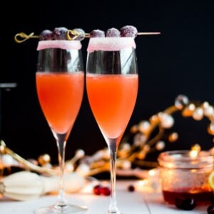 Homemade cranberry orange syrup takes this standby cocktail up a notch. Cranberry Sauce, Grand Marnier, Orange juice and cranberry orange syrup combine to make a festive winter cocktail. There is a non-alcoholic mocktail version as well!