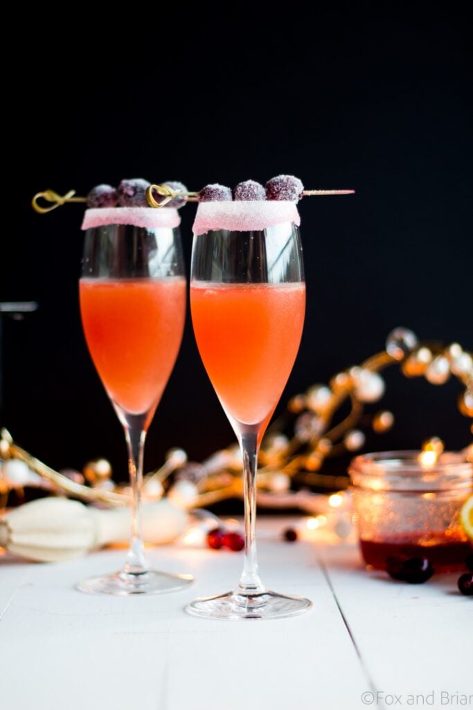 Homemade cranberry orange syrup takes this standby cocktail up a notch. Cranberry Sauce, Grand Marnier, Orange juice and cranberry orange syrup combine to make a festive winter cocktail. There is a non-alcoholic mocktail version as well!
