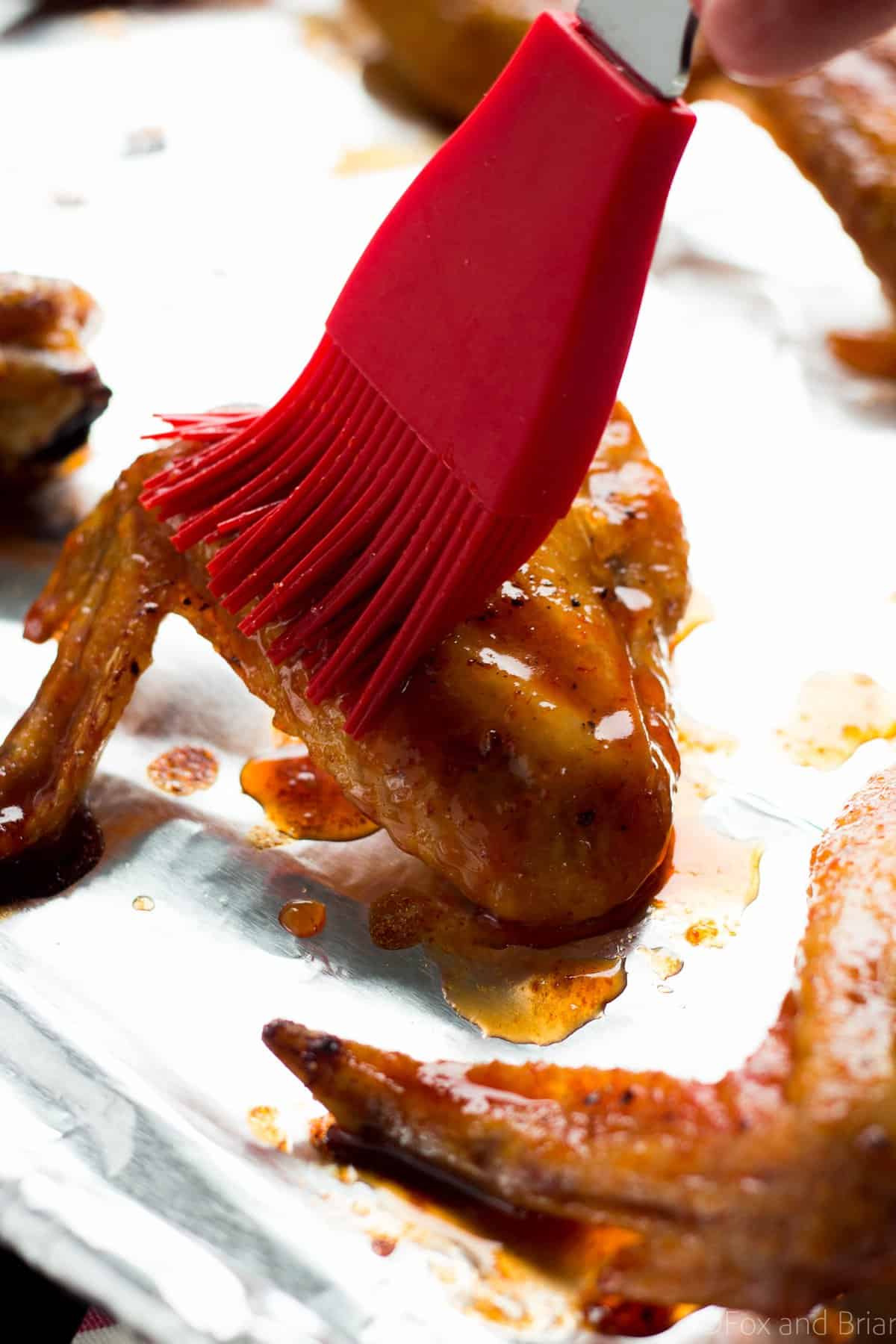 The key to getting crispy baked wings is a simple one.  Bake on a rack so that the fat that renders falls away from the chicken and allows it to crisp up.  I also put them in a cold oven and then turned on the heat.  I don't really know if that makes a huge difference but it does allow more fat to render.