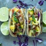 These Slow Cooker Pork Tacos let your slow cooker do most of the work. Crunchy purple cabbage, tender pork and a juicy pineapple mint salsa create a taco bursting with flavor!