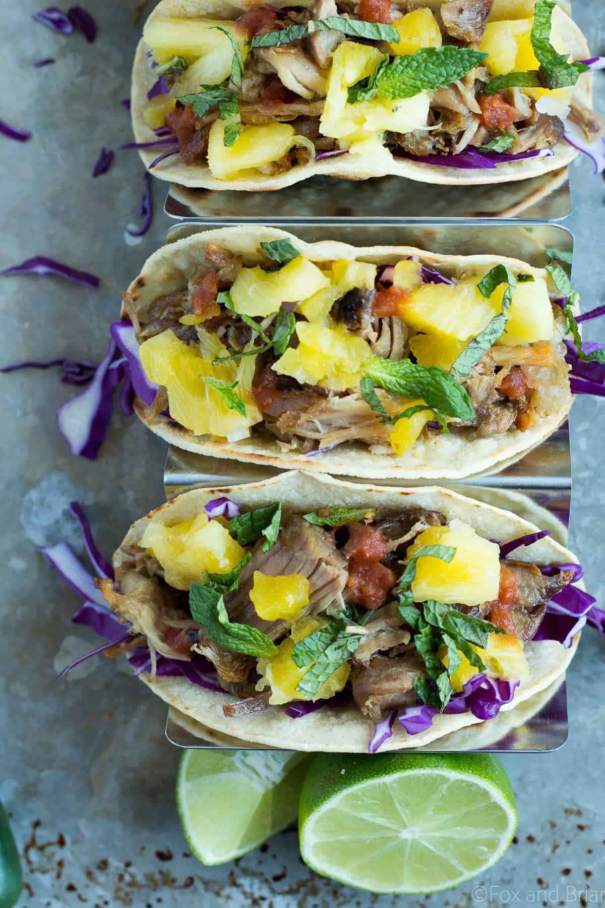 These Slow Cooker Pork Tacos let your slow cooker do most of the work. Crunchy purple cabbage, tender pork and a juicy pineapple mint salsa create a taco bursting with flavor!
