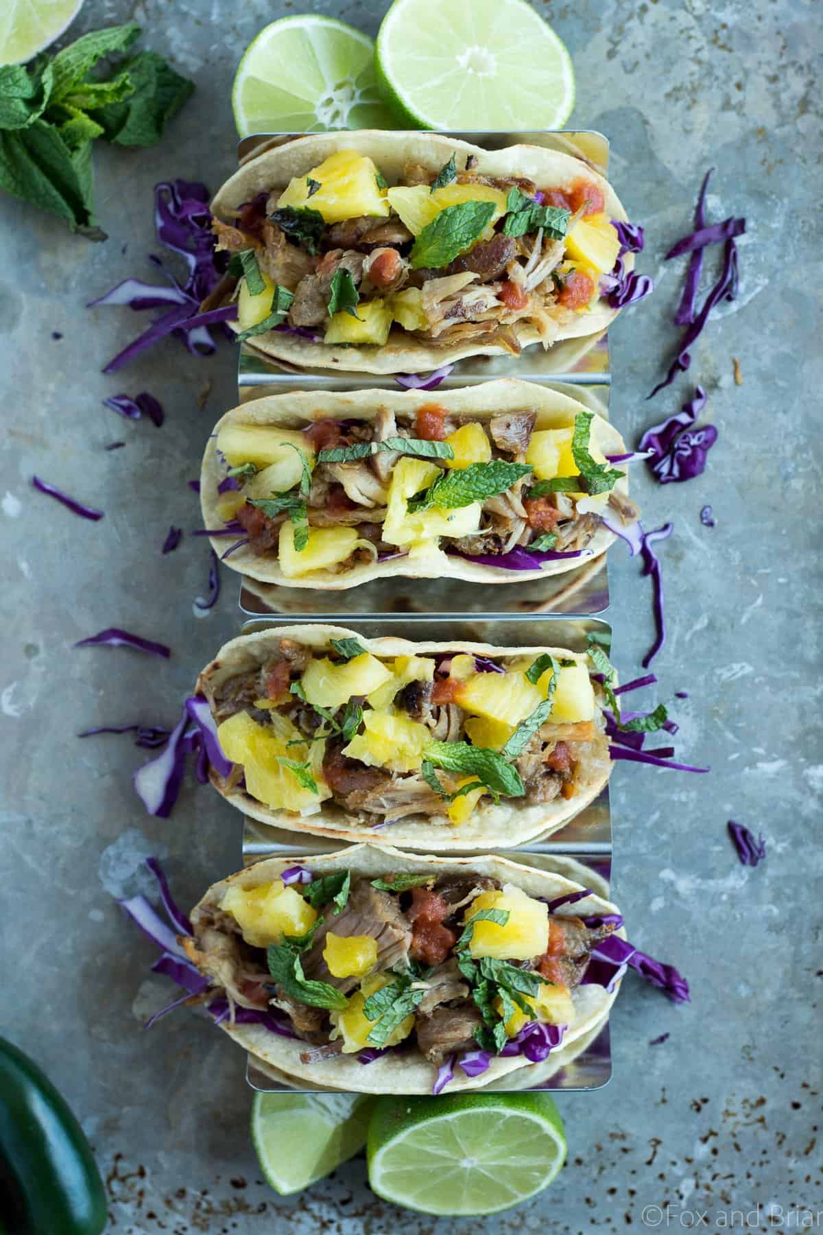 These Slow Cooker Pork Tacos let your slow cooker do most of the work. Crunchy purple cabbage, tender pork and a juicy pineapple mint salsa create a taco bursting with flavor!