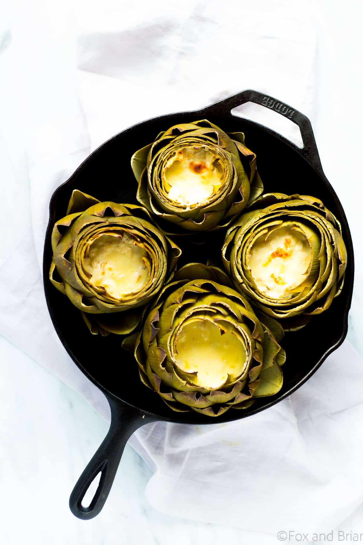 These Hot Crab Dip Stuffed Artichokes deserves a spot on your holiday or party table! Artichokes stuffed with a rich and cheesy crab dip, then baked until melty. You can use the artichoke leaves to scoop the dip!