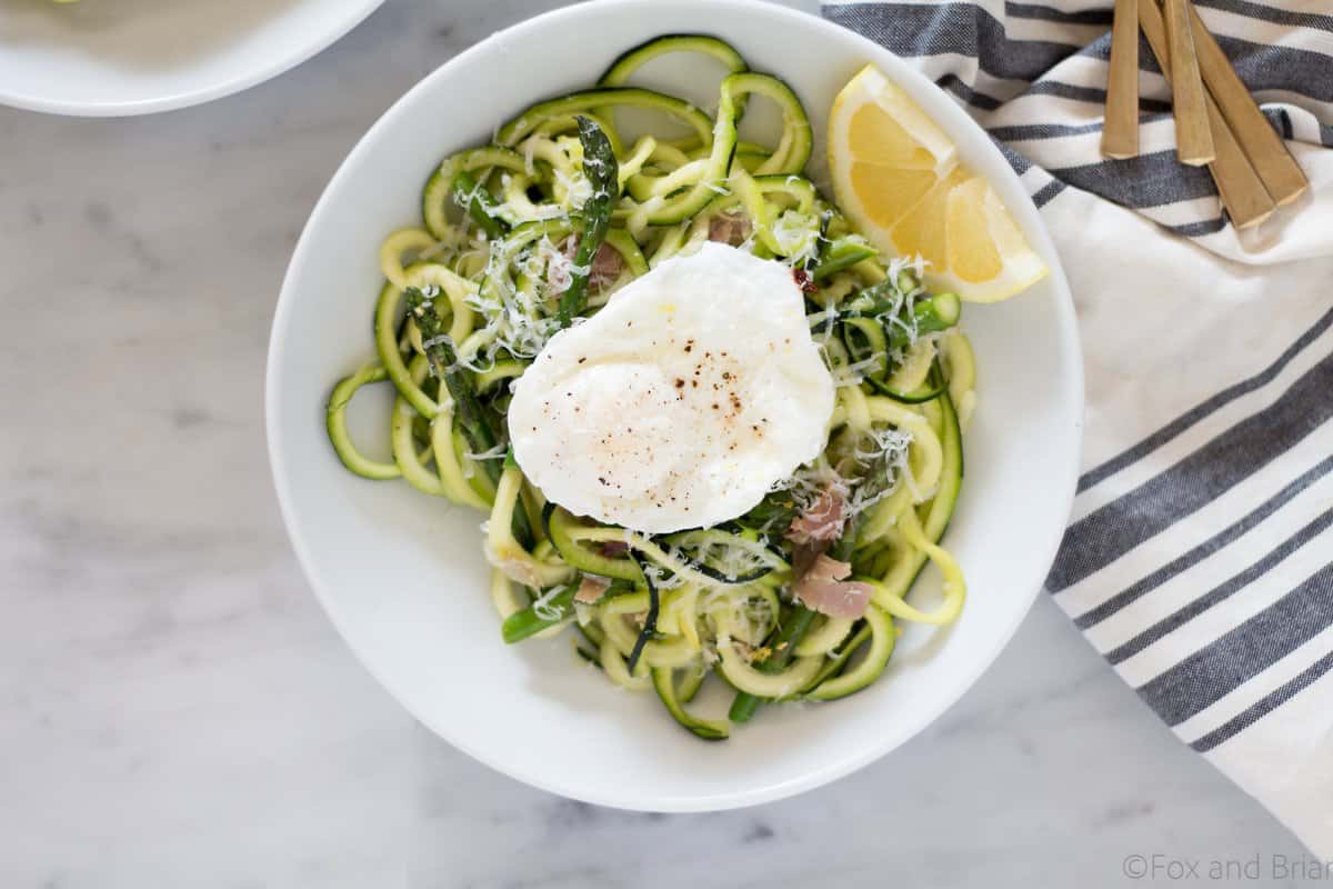 Zoodles (zuchinni noodles) quick cooked with asparagus,prosciutto , parmesan cheese, lemon and white wine all topped with a poached egg make a quick and light spring meal.