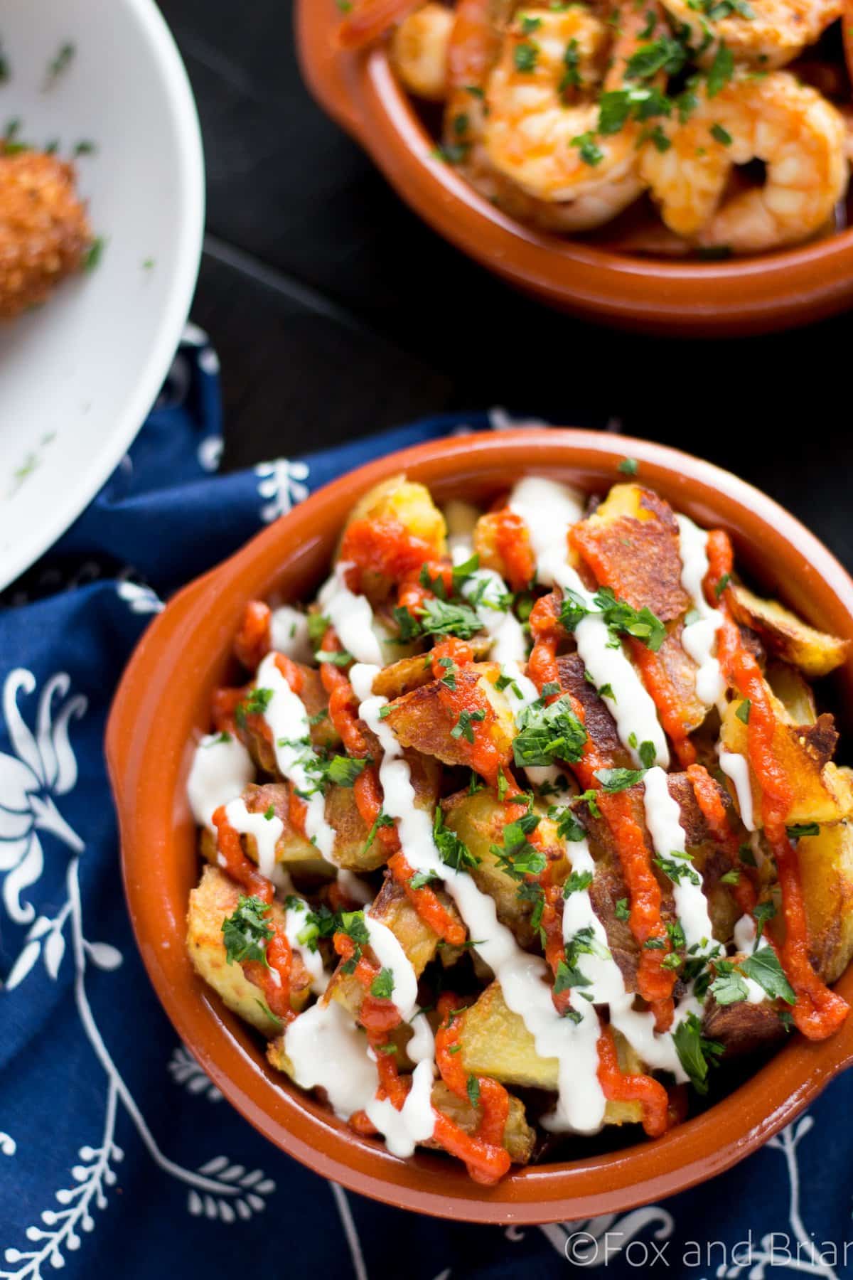 These patatas bravas are crispy even though they are baked not fried! Topped with a delicious smoky salsa brava and garlic aioli, they are totally addictive!