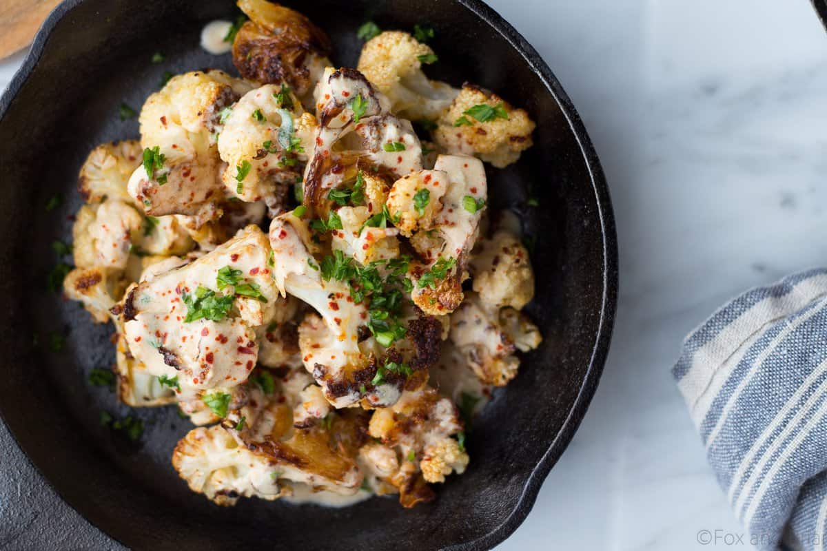 Roasted Cauliflower With Yogurt Sauce AND a dairy free tahini sauce! You won't beleive how addictive this dish is with caramelized cauliflower, a zingy yogurt sauce and a tasty tahini sauce for peope who prefer not to eat dairy.