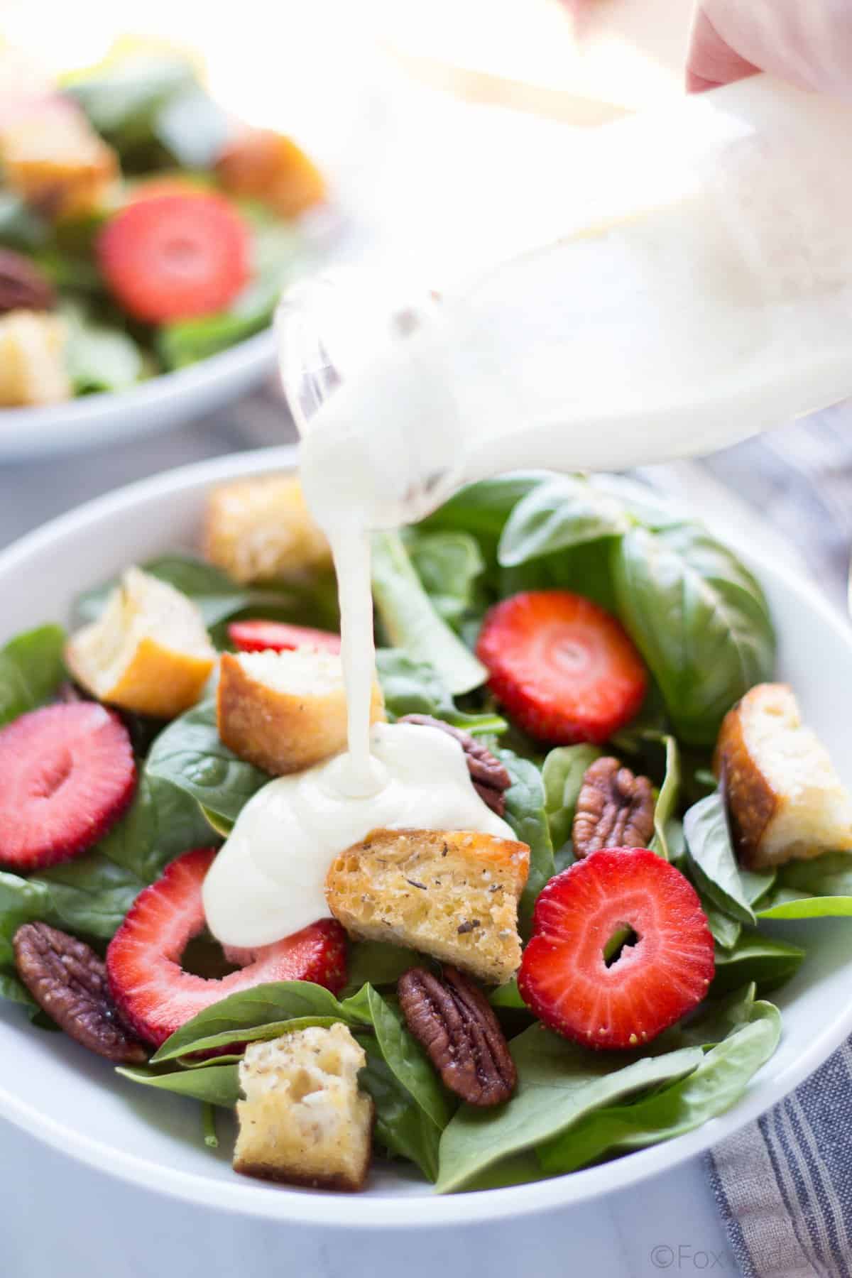 This Strawberry Basil Pecan Salad with Goat Cheese Dressing is a sweet and tangy summer salad bursting with fresh flavors and homemade croutons.