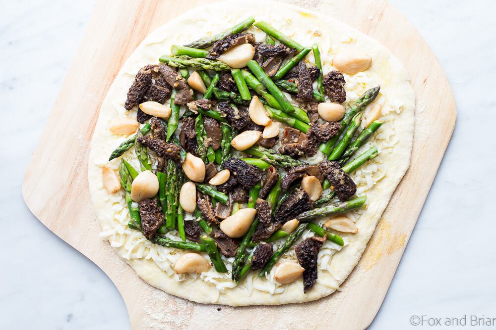 This Asparagus and Morel Pizza with Garlic Confit is the perfect way to use your spring produce! Garlicky and cheesey, packed full of flavor and vegetarian!