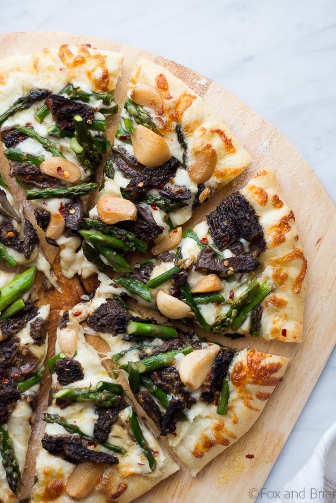 This Asparagus and Morel Pizza with Garlic Confit is the perfect way to use your spring produce! Garlicky and cheesey, packed full of flavor and vegetarian!