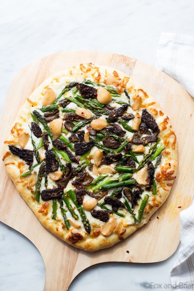 This Asparagus and Morel Pizza with Garlic Confit is the perfect way to use your spring produce! Garlicky and cheesey, packed full of flavor and vegetarian!