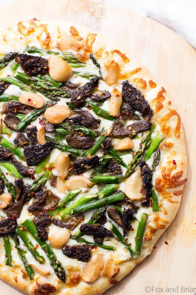 This Asparagus and Morel Pizza with Garlic Confit is the perfect way to use your spring produce! Garlicky and cheesey, packed full of flavor and vegetarian!