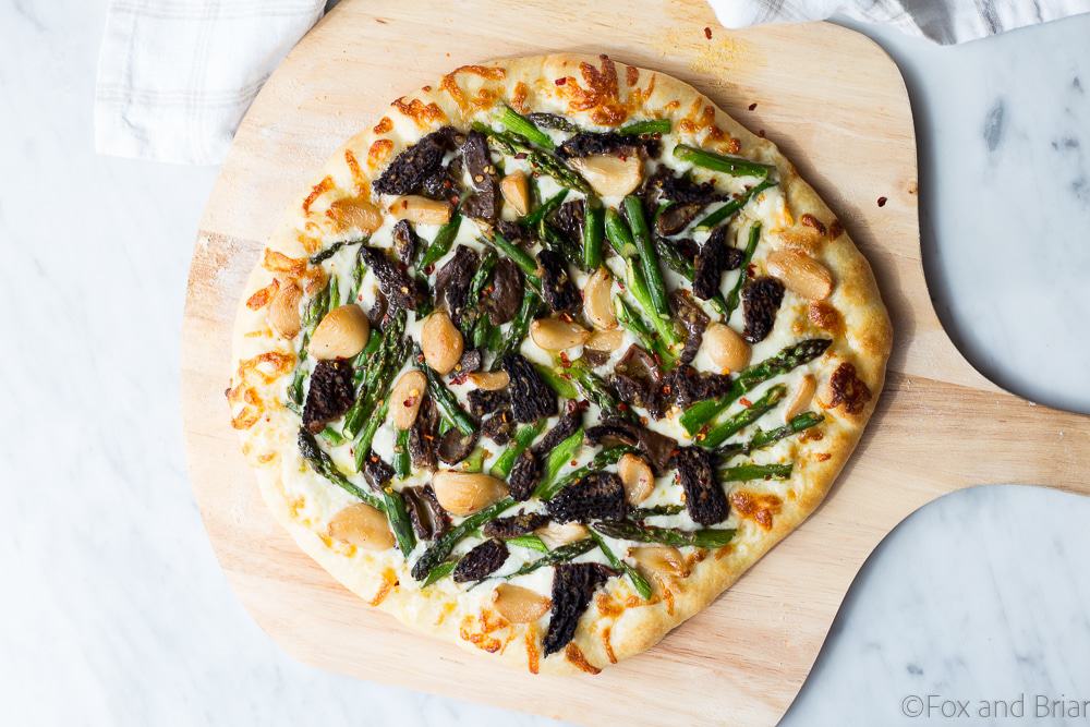 This Asparagus and Morel Pizza with Garlic Confit is the perfect way to use your spring produce! Garlicky and cheesy, packed full of flavor and vegetarian!