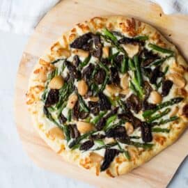This Asparagus and Morel Pizza with Garlic Confit is the perfect way to use your spring produce! Garlicky and cheesey, packed full of flavor and vegetarian!