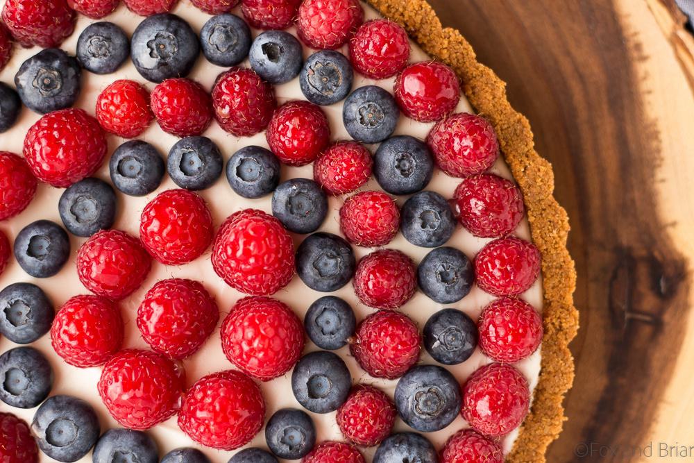 This Red, White and Blueberry Tart is a fresh berry tart perfect for 4th of July or any summer day! Fresh berries, a sweet creamy filling and a graham cracker crust make this simple and delicious tart a total winner!