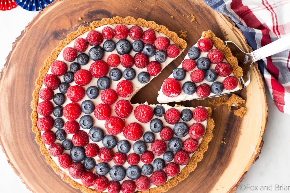 This Red, White and Blueberry Tart is a fresh berry tart perfect for 4th of July or any summer day! Fresh berries, a sweet creamy filling and a graham cracker crust make this simple and delicious tart a total winner!