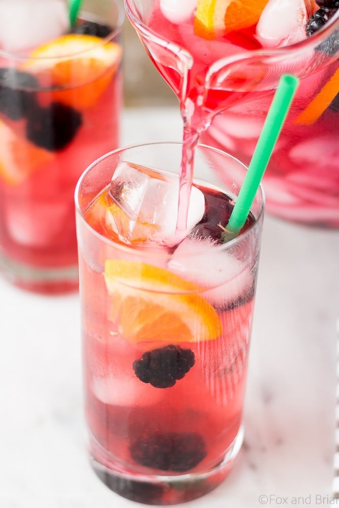 This Berry Sangria Iced Tea is a take on the Starbucks drink! Herbal iced tea mixed with a berry orange syrup, apple juice and blackberries! So refreshing for a hot summer day.