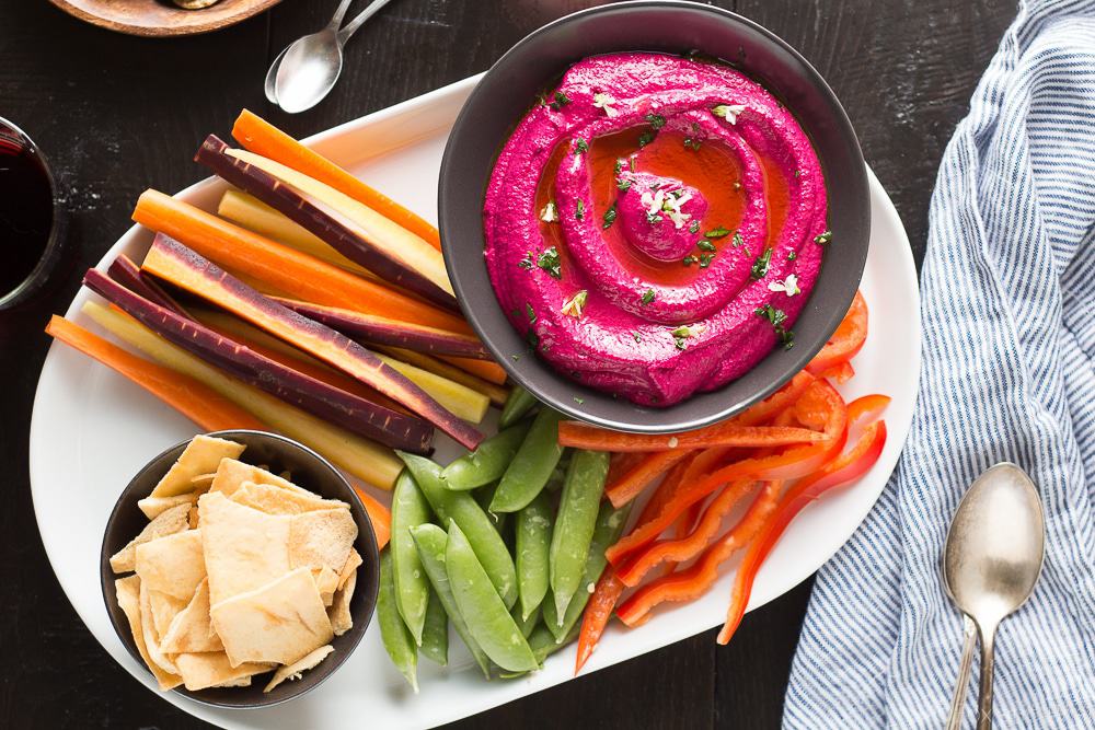 This Creamy Beet Hummus with Yogurt will soon be your favorite way to eat your beets! Roasted beets, tahini and yogurt are blended together to make a creamy and healthy dip with a bright pink color that will blow your mind!
