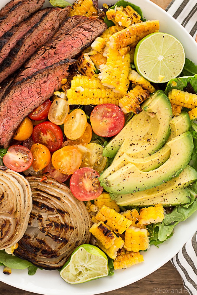 This Mexican Grilled Flank Steak Salad with Honey Lime Dressing has a smoky spiced grilled flank steak, charred corn, grilled onions, creamy avocado and a zingy honey lime dressing. Quick to make inside on the stove or outside on the grill!