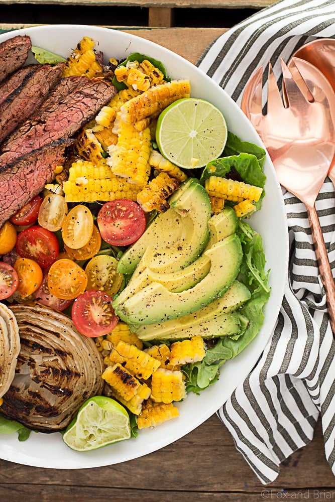 This Mexican Grilled Flank Steak Salad with Honey Lime Dressing has a smoky spiced grilled flank steak, charred corn, grilled onions, creamy avocado and a zingy honey lime dressing. Quick to make inside on the stove or outside on the grill!