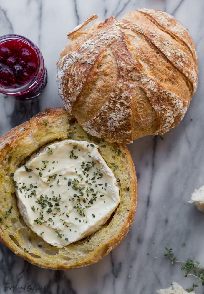 This Tear Apart Baked Cranberry Brie Bread Bowl is a beautiful holiday party appetizer. Melty brie and sweet tart cranberry sauce are a match made in heaven! | Baked Brie | Bloomin' Brie Bread Bowl | Holiday baked brie | Brie and cranberry appetizer | Christmas Appetizer | Thanksgiving Appetizer | New Years Appetizer | Appetizer for parties | Baked Brie Dip in bread 