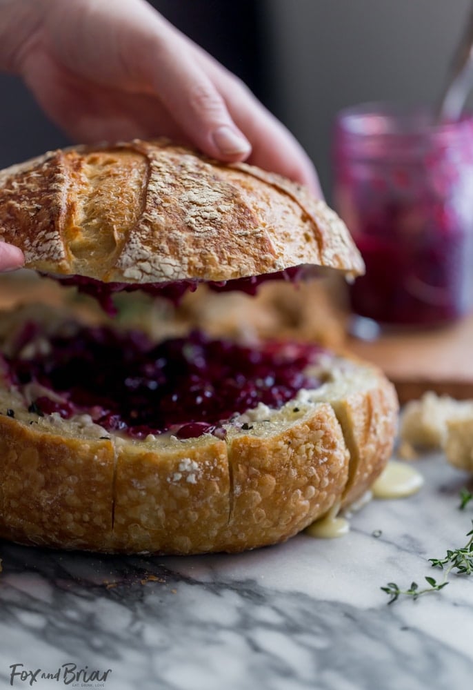 This Tear Apart Baked Cranberry Brie Bread Bowl is a beautiful holiday party appetizer. Melty brie and sweet tart cranberry sauce are a match made in heaven! | Baked Brie | Bloomin' Brie Bread Bowl | Holiday baked brie | Brie and cranberry appetizer | Christmas Appetizer | Thanksgiving Appetizer | New Years Appetizer | Appetizer for parties | Baked Brie Dip in bread