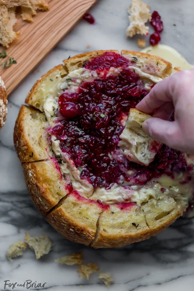 This Tear Apart Baked Cranberry Brie Bread Bowl is a beautiful holiday party appetizer. Melty brie and sweet tart cranberry sauce are a match made in heaven! | Baked Brie | Bloomin' Brie Bread Bowl | Holiday baked brie | Brie and cranberry appetizer | Christmas Appetizer | Thanksgiving Appetizer | New Years Appetizer | Appetizer for parties | Baked Brie Dip in bread