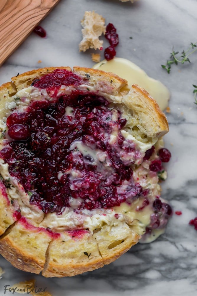 This Tear Apart Baked Cranberry Brie Bread Bowl is a beautiful holiday party appetizer. Melty brie and sweet tart cranberry sauce are a match made in heaven! | Baked Brie | Bloomin' Brie Bread Bowl | Holiday baked brie | Brie and cranberry appetizer | Christmas Appetizer | Thanksgiving Appetizer | New Years Appetizer | Appetizer for parties | Baked Brie Dip in bread