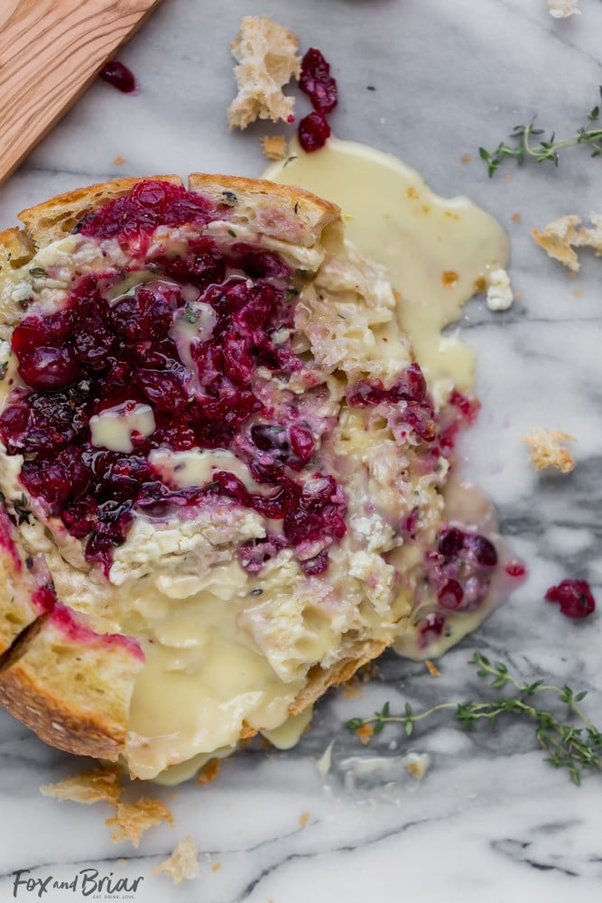 This Tear Apart Baked Cranberry Brie Bread Bowl is a beautiful holiday party appetizer. Melty brie and sweet tart cranberry sauce are a match made in heaven! | Baked Brie | Bloomin' Brie Bread Bowl | Holiday baked brie | Brie and cranberry appetizer | Christmas Appetizer | Thanksgiving Appetizer | New Years Appetizer | Appetizer for parties | Baked Brie Dip in bread