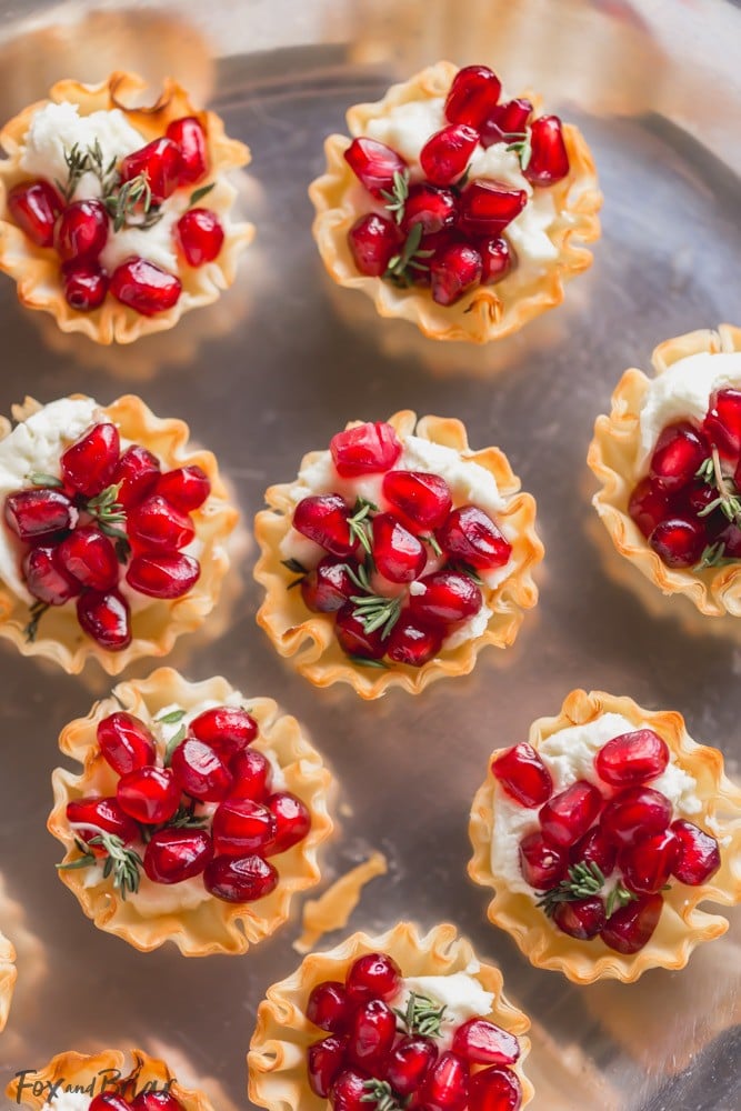 These Pomegranate Goat Cheese Bites with Honey and Thyme are an easy party appetizer that is sure to impress your guests! | easy party appetizer | phyllo bite recipe | Phyllo dough recipe | mini phyllo shells appetizers | phyllo dough hors d'oeuvres recipes | finger foods | holiday appetizer recipe | elegant party appetizer | girls night | apps | new years eve party recipe | thanksgiving appetizer | 