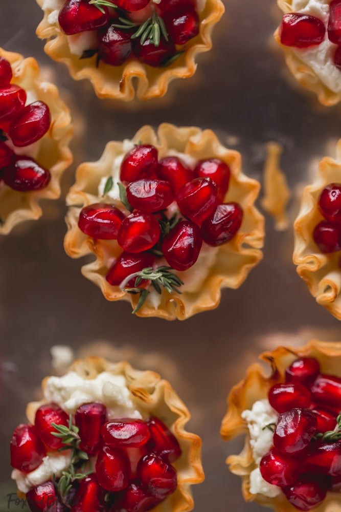 These Pomegranate Goat Cheese Bites with Honey and Thyme are an easy party appetizer that is sure to impress your guests! | easy party appetizer | phyllo bite recipe | Phyllo dough recipe | mini phyllo shells appetizers | phyllo dough hors d'oeuvres recipes | finger foods | holiday appetizer recipe | elegant party appetizer | girls night | apps | new years eve party recipe | thanksgiving appetizer | 