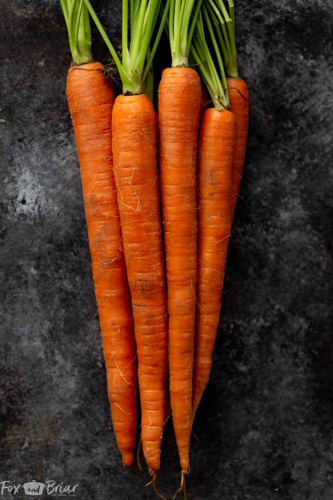 These Honey Roasted Carrots with thyme are cooked in the oven, giving them a beautiful glaze!  This is one of the best carrot recipes I have ever eaten! Make these simple oven roasted carrots for an easy but impressive side dish for Easter or any other dinner! | Side dish for easter | side dish for mother's day | Spring recipe | carrot recipe | how to cook carrots | Glazed Carrots | Oven baked carrots