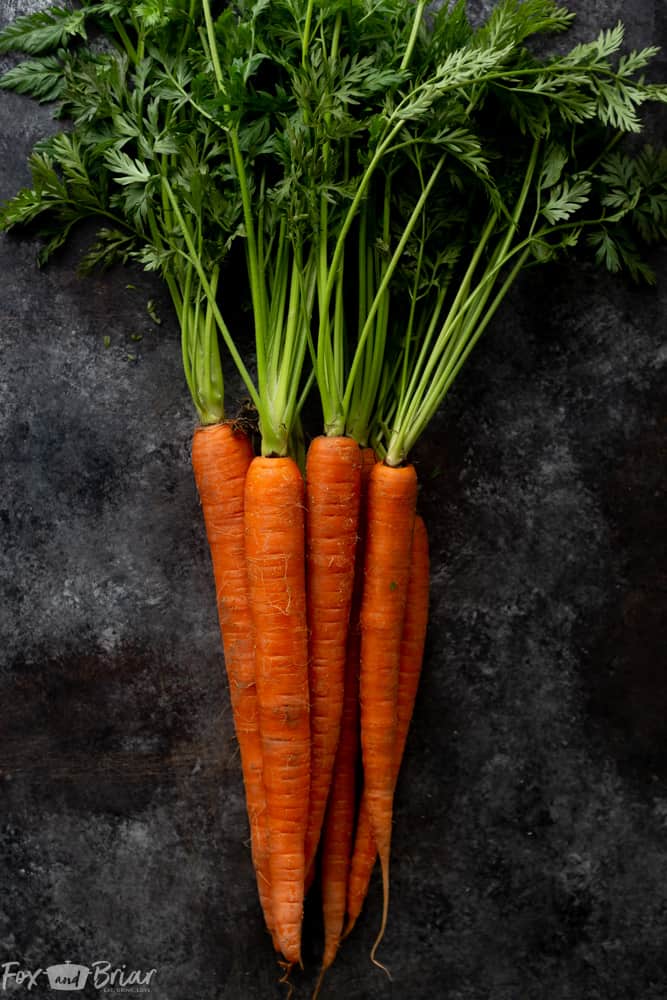 These Honey Roasted Carrots with thyme are cooked in the oven, giving them a beautiful glaze!  This is one of the best carrot recipes I have ever eaten! Make these simple oven roasted carrots for an easy but impressive side dish for Easter or any other dinner! | Side dish for easter | side dish for mother's day | Spring recipe | carrot recipe | how to cook carrots | Glazed Carrots | Oven baked carrots