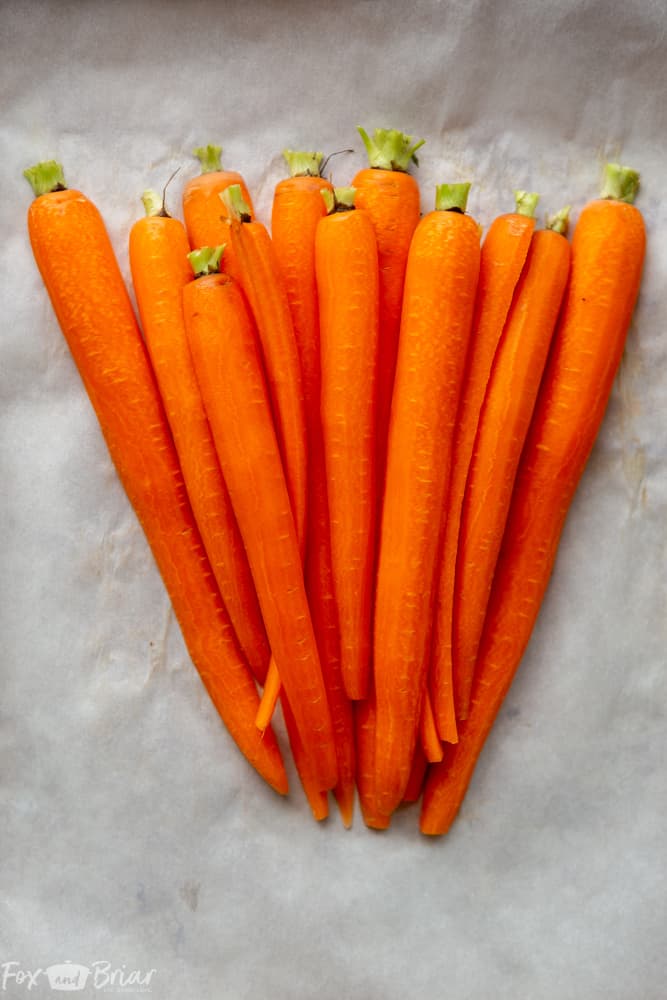 These Honey Roasted Carrots with thyme are cooked in the oven, giving them a beautiful glaze!  This is one of the best carrot recipes I have ever eaten! Make these simple oven roasted carrots for an easy but impressive side dish for Easter or any other dinner! | Side dish for easter | side dish for mother's day | Spring recipe | carrot recipe | how to cook carrots | Glazed Carrots | Oven baked carrots