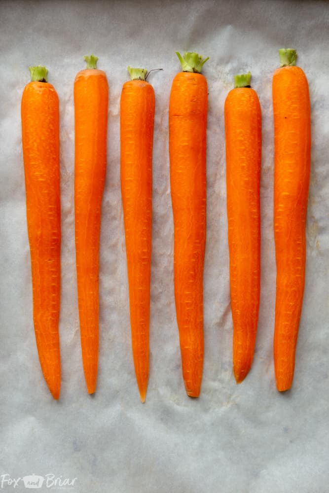 These Honey Roasted Carrots with thyme are cooked in the oven, giving them a beautiful glaze!  This is one of the best carrot recipes I have ever eaten! Make these simple oven roasted carrots for an easy but impressive side dish for Easter or any other dinner! | Side dish for easter | side dish for mother's day | Spring recipe | carrot recipe | how to cook carrots | Glazed Carrots | Oven baked carrots