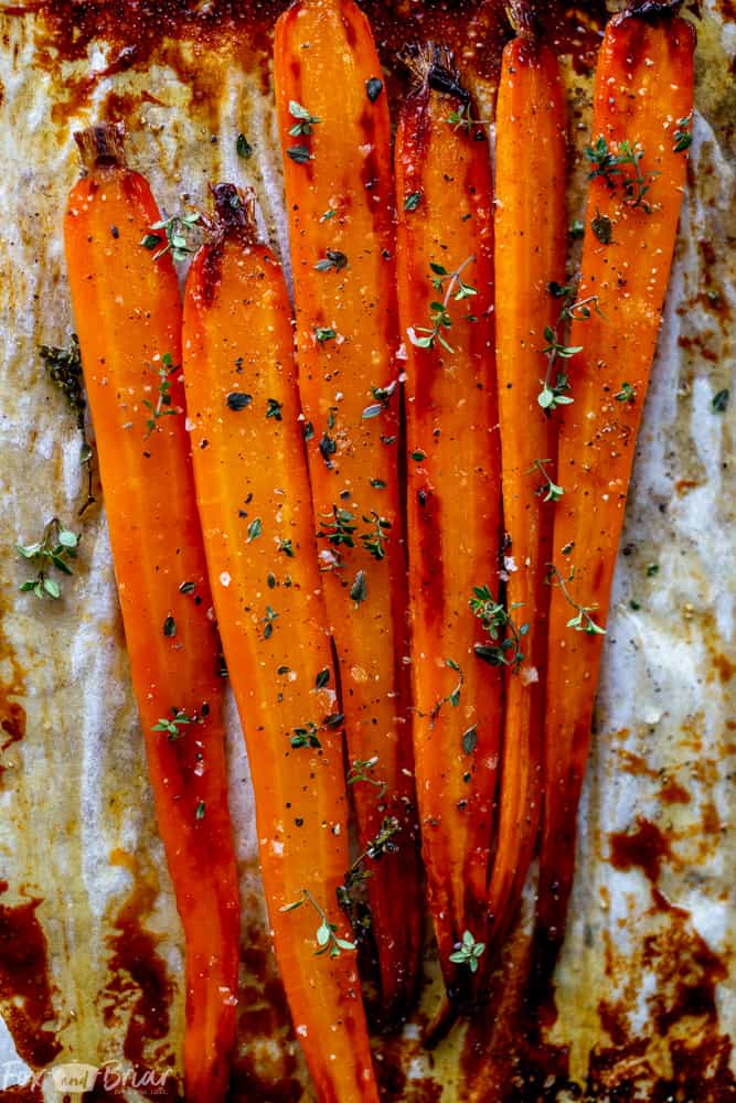 These Honey Roasted Carrots with thyme are cooked in the oven, giving them a beautiful glaze!  This is one of the best carrot recipes I have ever eaten! Make these simple oven roasted carrots for an easy but impressive side dish for Easter or any other dinner! | Side dish for easter | side dish for mother's day | Spring recipe | carrot recipe | how to cook carrots | Glazed Carrots | Oven baked carrots