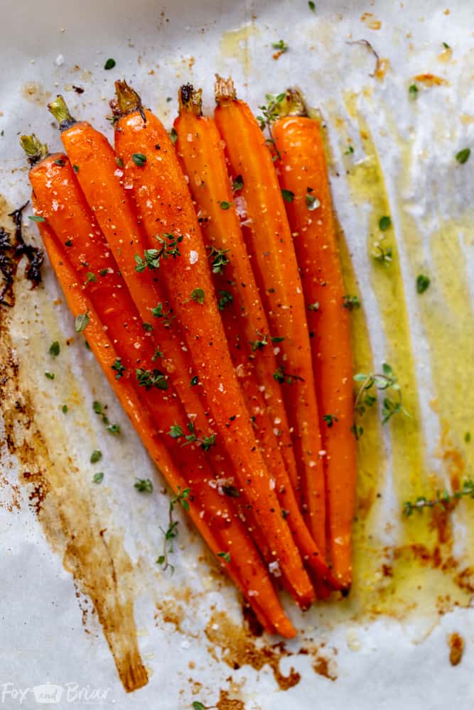 These Honey Roasted Carrots with thyme are cooked in the oven, giving them a beautiful glaze!  This is one of the best carrot recipes I have ever eaten! Make these simple oven roasted carrots for an easy but impressive side dish for Easter or any other dinner! | Side dish for easter | side dish for mother's day | Spring recipe | carrot recipe | how to cook carrots | Glazed Carrots | Oven baked carrots