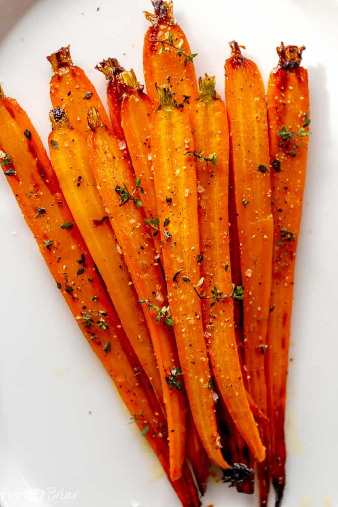 These Honey Roasted Carrots with thyme are cooked in the oven, giving them a beautiful glaze!  This is one of the best carrot recipes I have ever eaten! Make these simple oven roasted carrots for an easy but impressive side dish for Easter or any other dinner! | Side dish for easter | side dish for mother's day | Spring recipe | carrot recipe | how to cook carrots | Glazed Carrots | Oven baked carrots