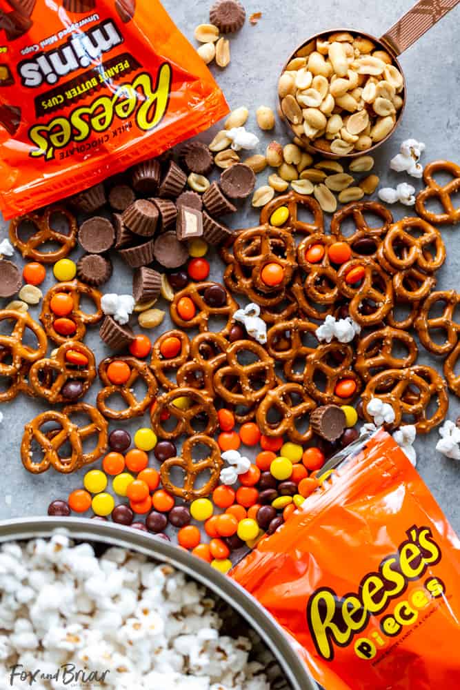 This Chocolate Peanut Butter Sweet and Salty Popcorn Snack Mix is perfect to serve at your next game day party!  Keep them coming back for more with popcorn mixed with Reese's Pieces, Reese’s Peanut Butter Cups Minis , pretzels and peanuts, all mixed together with caramel. #ad @krogerco @reeses | Popcorn recipes | popcorn ideas | sweet poporn recipe | caramel corn | peanut butter chocolate 