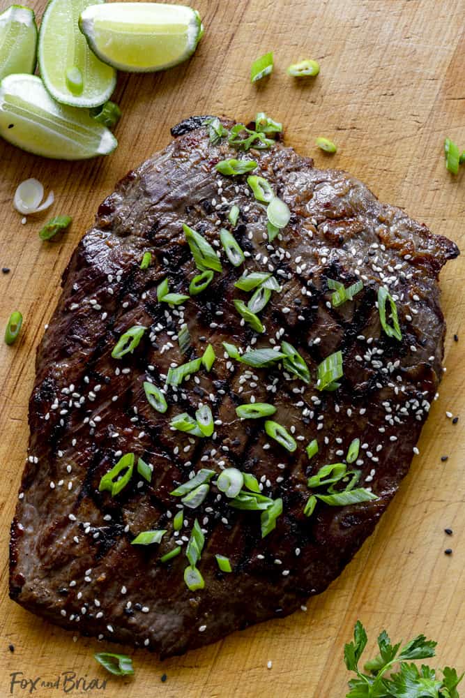 Grilled flank steak with sesame seeds and green onion garnish