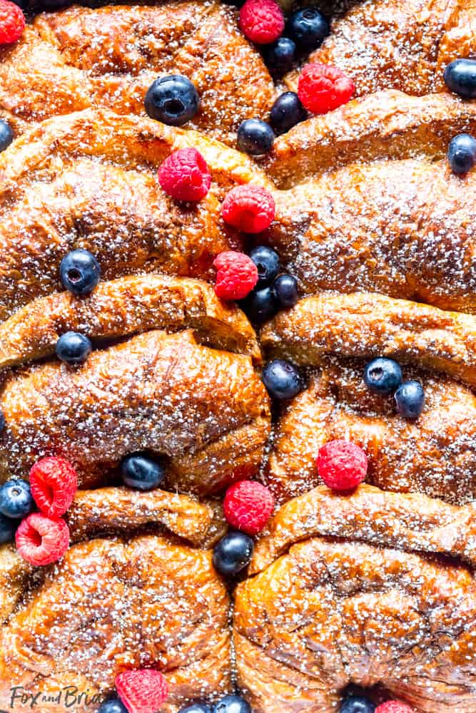 Close up of Croissant French Toast in pan with berries scattered on top