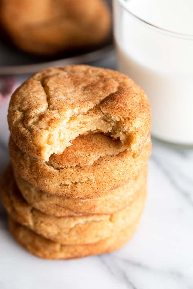 A stack of five snickerdoodle cookies with a bite taken out of the top one.