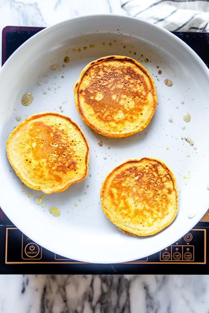 Cooked pancakes on a white frying pan